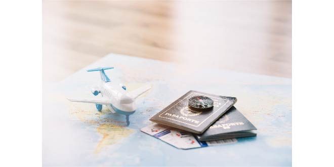 White toy airplane; compass on passports and baggage allowances card on map against wooden table Free Phot